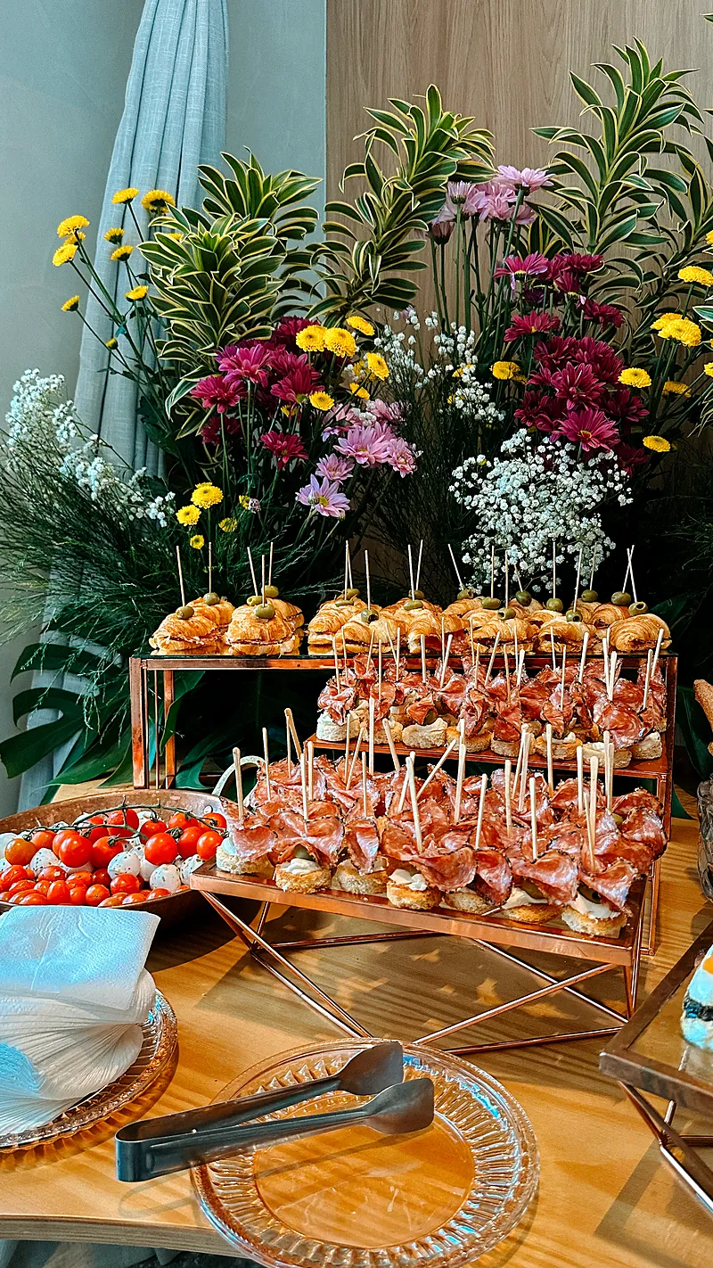 Mesa de doces com flores do campo ao fundo