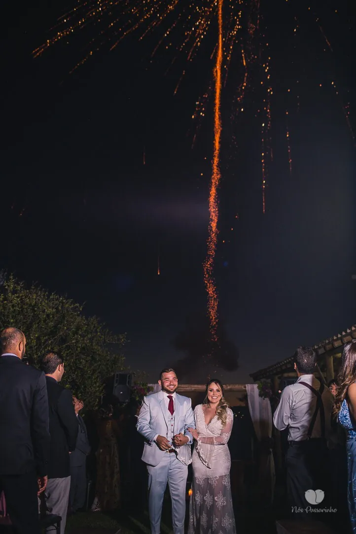 Noivos celebrando à noite sob fogos de artifício