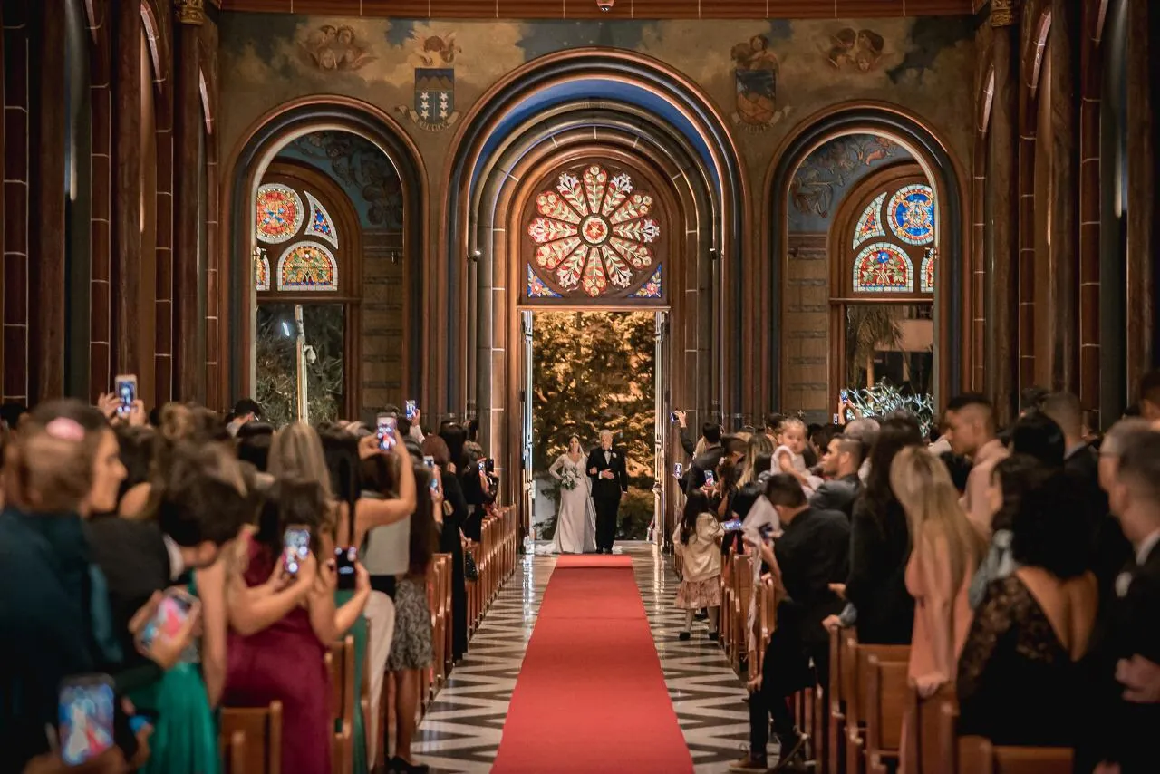 Entrada da noiva pelo corredor de uma igreja com vitrais