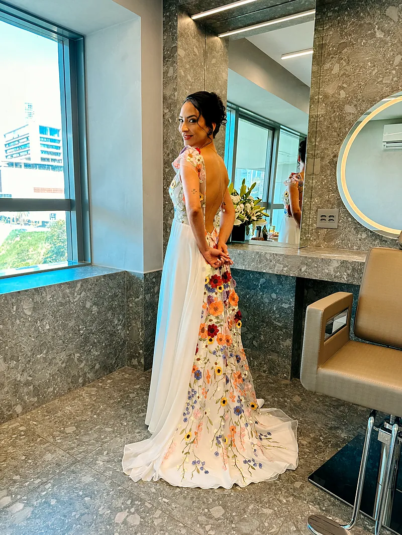 Noiva de costas com vestido bordado de flores coloridas